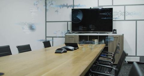 Modern Boardroom Showing Long Wooden Conference Table, Speakerphones and Wall-Mounted Monitor