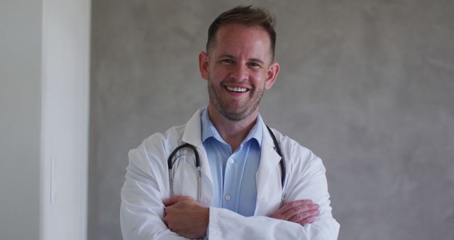 Smiling healthcare professional wearing white coat and stethoscope, standing confidently with arms crossed. Ideal for medical blogs, healthcare websites, hospital advertising, and doctor-patient communication visual materials.