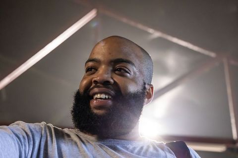 African american man smiling backlit headshot industrial warehouse portrait for branding