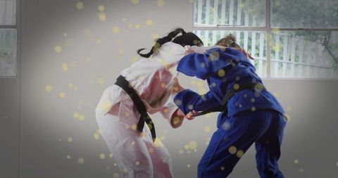 Dynamic grappling in judo dojo with golden sparkle overlay