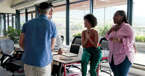 Excited colleagues celebrating success in modern office