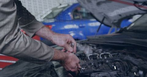Mechanic Repairing Car Engine with Wrench under Open Hood in Garage Workshop