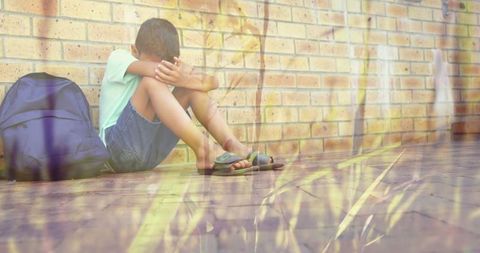 Lonely Schoolboy Sitting by Brick Wall