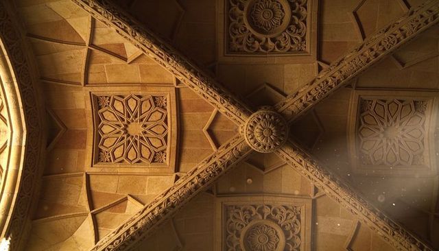Ornate vaulted chapel ceiling with intersecting carved stone ribs and central rosette