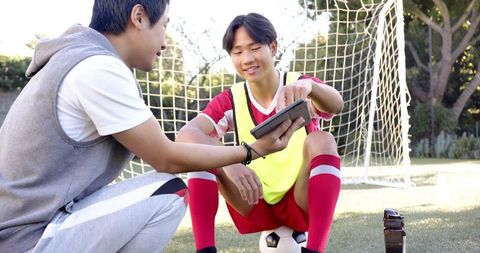 Coach Explains Tactics to Soccer Player on Field