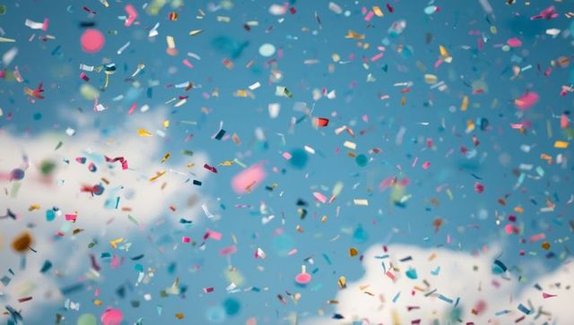 Vibrant Festive Confetti Falling Against Bright Blue Sky