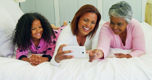 Multigenerational Family Bonding with Smartphone on Bed - Download Free Stock Images Pikwizard.com