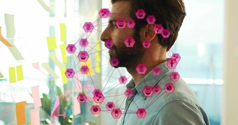 Bearded Professional Studying Sticky Notes on Glass Wall with Magenta Network Overlay