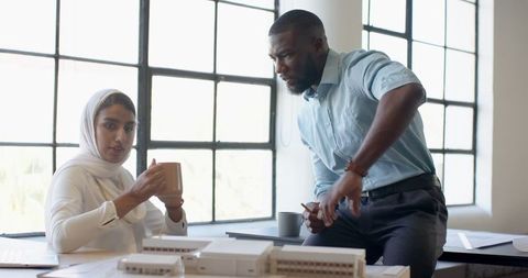 Colleagues Collaborating Over Architectural Model in Modern Office