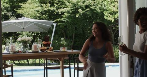 Woman Setting Up Elegant Poolside Event with Desserts and Drinks