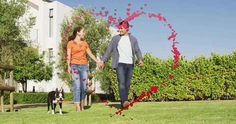 Joyful couple walking dog with heart motif