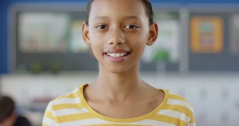 Smiling Schoolgirl Standing in Classroom For Learning Enthusiasm