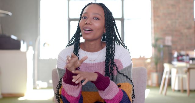 Woman in Colorful Sweater Speaking in Modern Office Environment - Download Free Stock Images Pikwizard.com