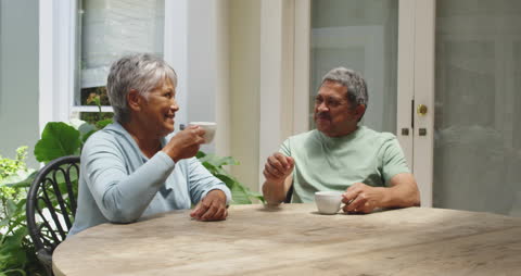 Senior Couple Enjoying Coffee in Sunlit Garden