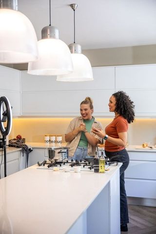 Friends cooking together using ring light in modern kitchen