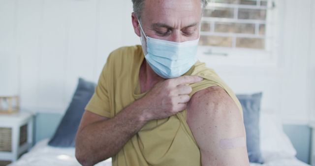 Man Showing Vaccination Bandage at Home - Download Free Stock Images Pikwizard.com