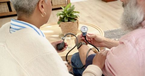Senior couple monitoring blood pressure with sphygmomanometer
