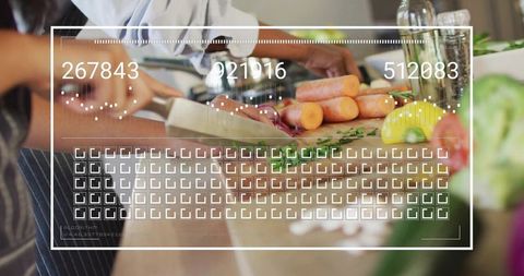 Two cooks slicing carrots on wooden board wearing aprons with digital overlay