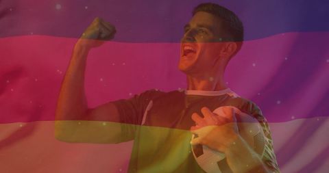 caucasian male football player is holding soccer ball, fist raised in a celebratory manner, overlaid with transparent german flag. perfect for illustrating sporting spirit or promoting events related to germany or football. use in promotional material for sports events, fitness motivation, or international football news.