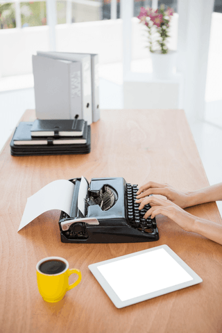 Human hands typing on vintage typewriter in transparent workspace