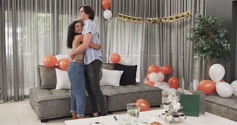 Cheerful Couple Celebrating Birthday with Dance in Festive Living Room