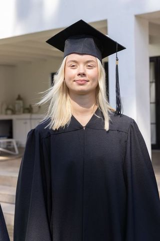 Proud Female Graduate Wearing Cap and Gown Outdoors