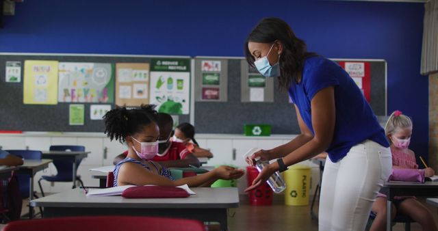 Teacher Distributing Hand Sanitizer to Students in Classroom During Pandemic - Download Free Stock Images Pikwizard.com