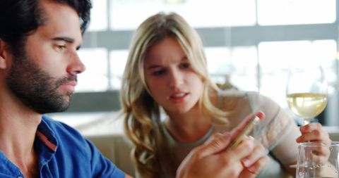 Young Couple Having Serious Discussion with Smartphone