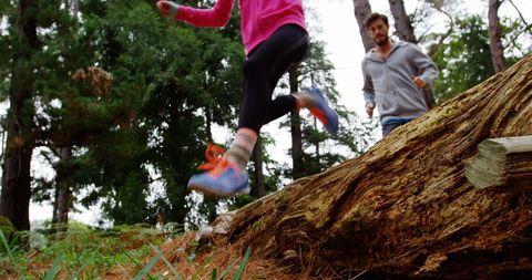 Young Runners Leaping Over Log in Forest Trail Adventure - Download Free Stock Images Pikwizard.com