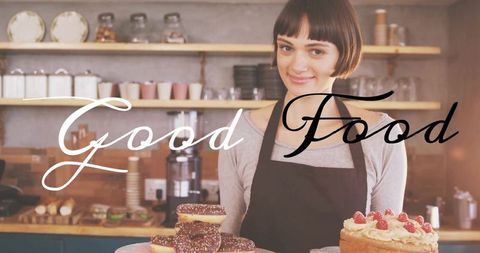 Smiling bakery worker presenting donuts and cake at cozy rustic cafe counter