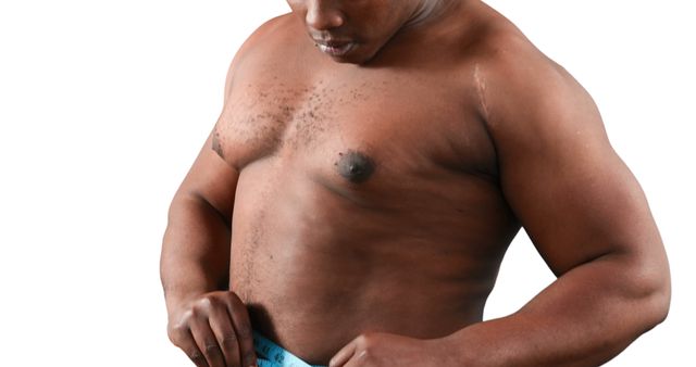 An African American middle-aged man appears shirtless, examining his own abdomen, with copy space. His posture suggests a focus on health, fitness, or body image concerns.