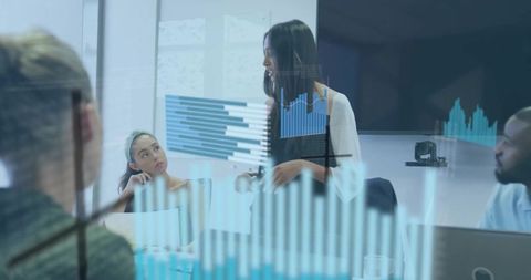 Presenting team analyzing transparent data charts on glass in modern boardroom meeting