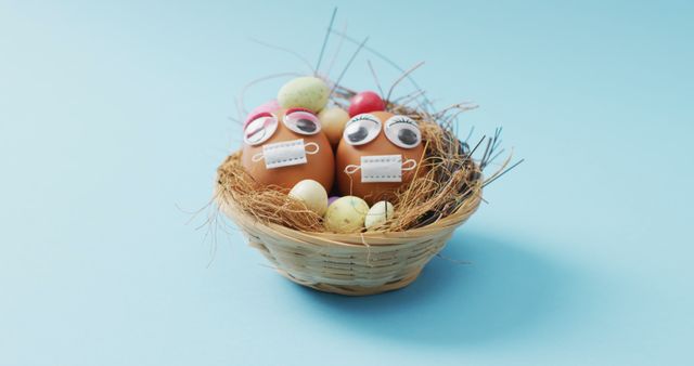 Image of eggs with eyes and face masks on a blue surface. seasonal easter traditional sweet treats during covid 19 pandemic.