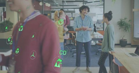 Young professionals collaborating in modern open-plan office with sustainability icons overlay