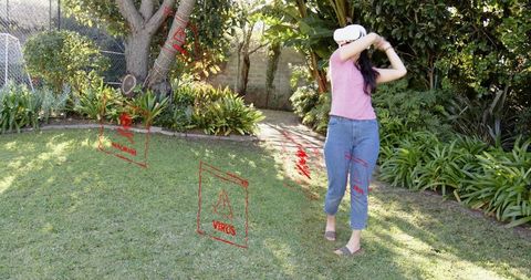 Woman wearing vr headset in backyard interacting with augmented virus overlays