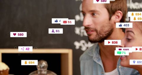 Couple at coffeehouse engaging with social media notifications showing likes comments