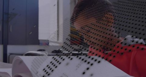 Teen boy studying at classroom desk with open textbook, dotted overlay and natural light