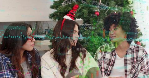 Multicultural friends chatting near christmas tree wearing festive headbands, data overlay