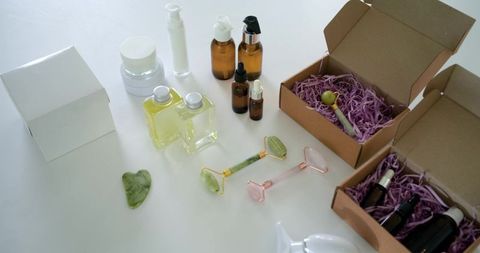 Minimalist skincare flatlay with jade and rose quartz rollers, gua sha, amber bottles