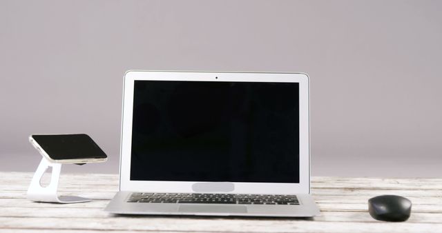 Modern Workspace with Laptop, Smartphone on Stand, and Mouse - Download Free Stock Images Pikwizard.com