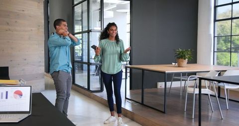Cheerful colleagues celebrating success in modern office