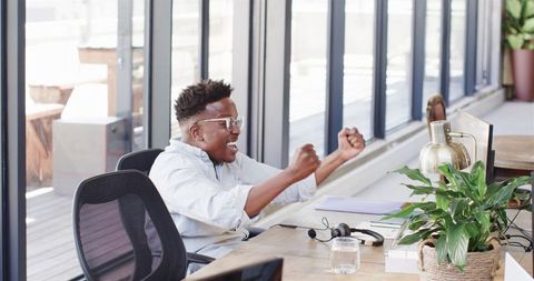 Excited business professional celebrating success in modern office