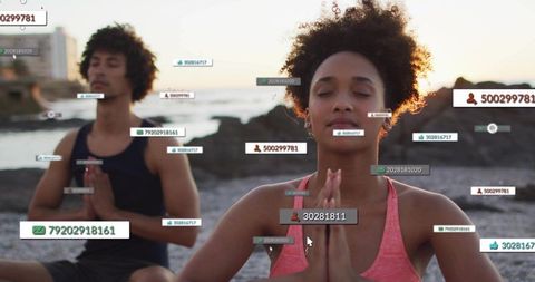 Couple meditating on rocky shore at sunset with floating social media data labels and cursor