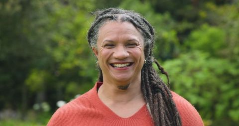 Smiling Woman Enjoying Nature in Lush Garden