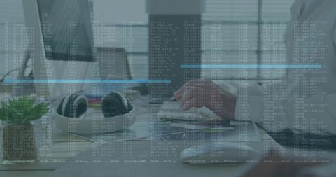Working man using mouse and keyboard at modern office desk with digital data overlay ui