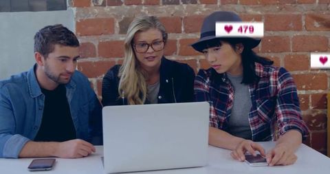 Colleagues Analyzing Social Media Metrics on Laptop at Office Table