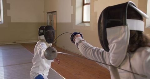 Female Fencers in Intense Duel Indoors with Swordsmen Gear - Download Free Stock Images Pikwizard.com