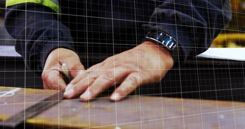 Carpenter marking precise cut line on wood plank with pencil and metal ruler