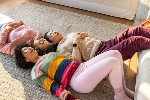 Diverse women relaxing with cucumber eye masks during cozy home self care session