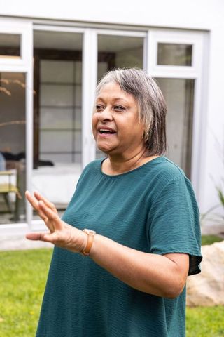 Senior woman gesturing in peaceful outdoor setting